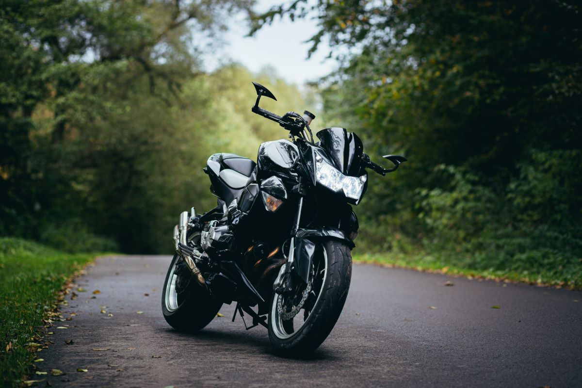 black-sports-motorcycle-stands-beautiful-forest-road